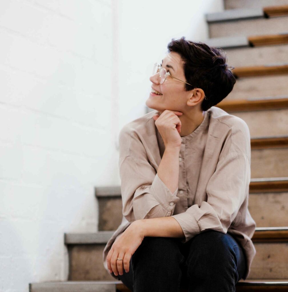 Deborah Hucht im Porträt auf einer Treppe sitzend