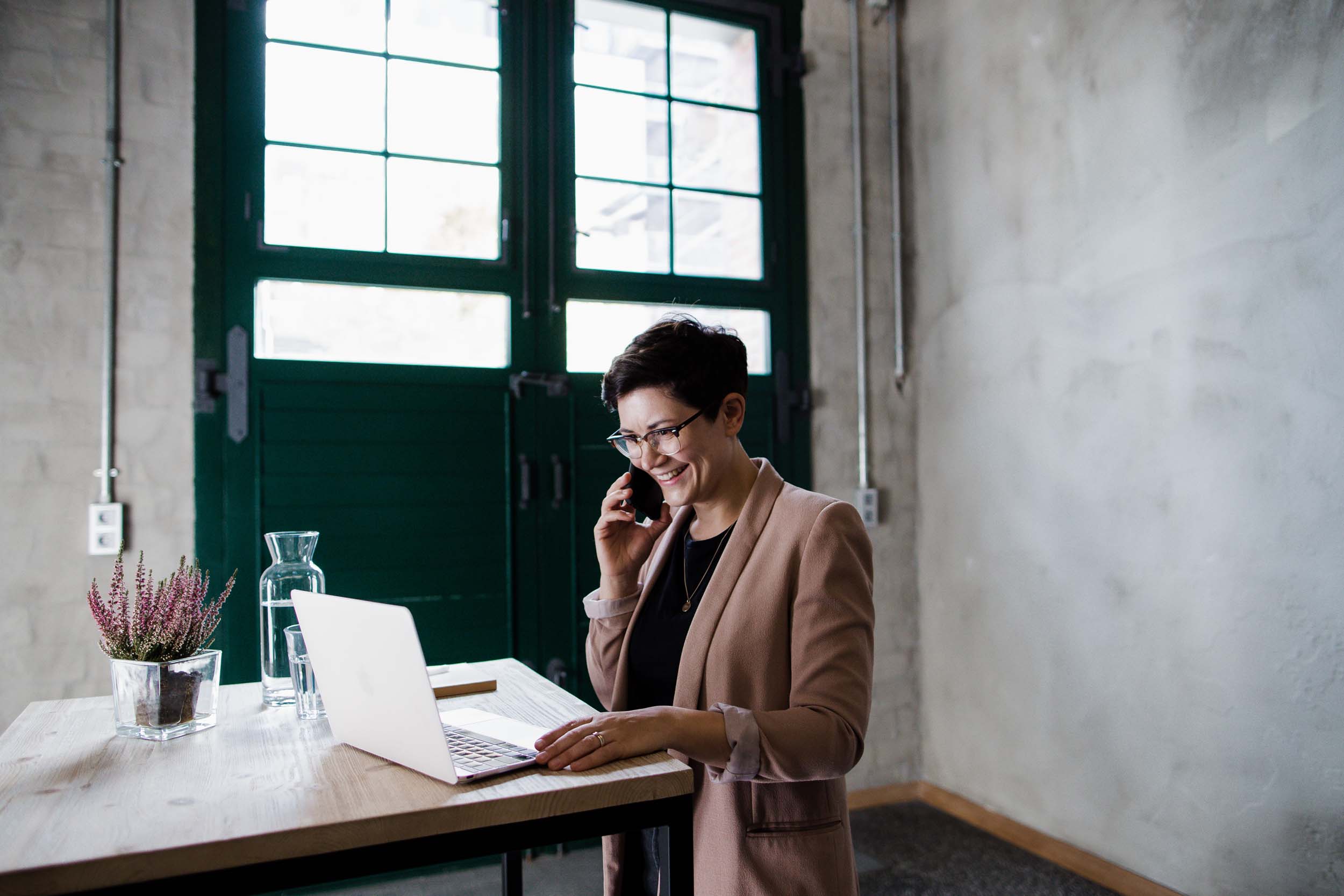 Symbolbild Content-Marketing-Beratung: Deborah Hucht telefoniert mit Kund*innen, während sie vor ihrem Macbook steht. 