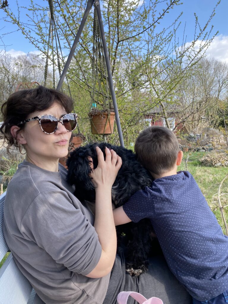 Deborah Hucht mit Hund und Kind im Garten.